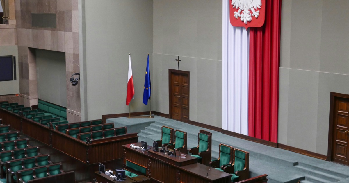 Sala posiedzeń Sejmu z polską flagą i godłem państwowym